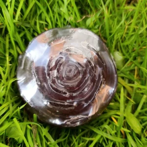 Jabón artesanal de canela Rosemary Herbal en forma redonda sobre pasto verde.