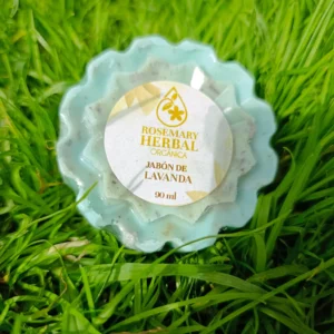 Jabón natural artesanal de lavanda color lila con forma floral sobre césped verde.