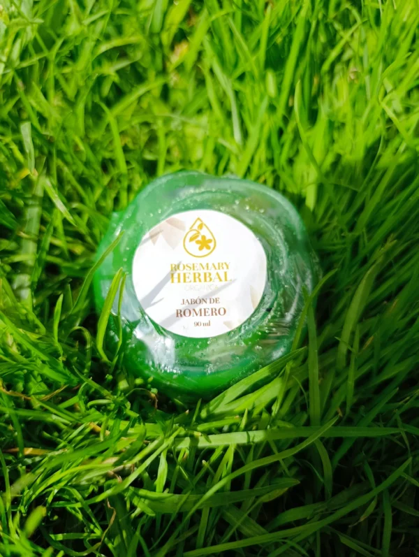 Jabón natural de romero Rosemary Herbal de 90 ml sobre pasto verde, ideal para piel grasa y tratamientos capilares.