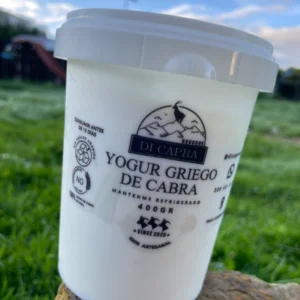 Envase de yogur griego de cabra artesanal sobre piedra natural.