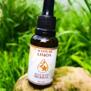 Frasco de aceite esencial de limón sobre piedra en campo verde, ideal para aromaterapia, limpieza y revitalización natural.